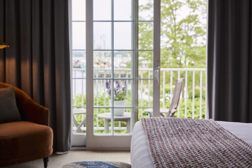 The foot of a guest bed, overlooking the harbor from the deck.
