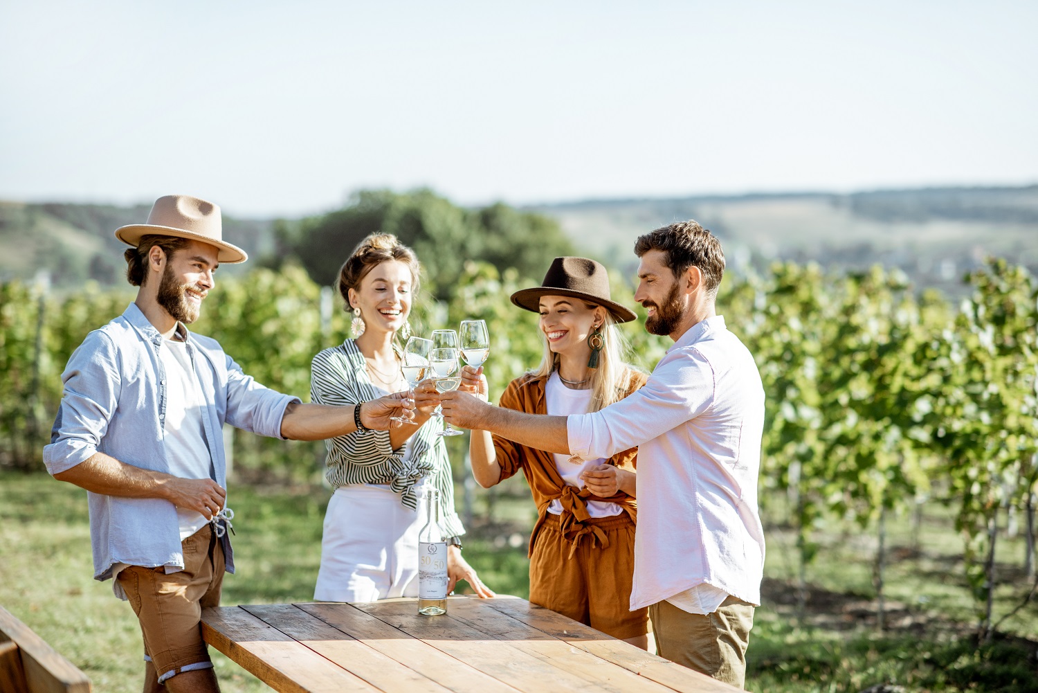 Friends toasting wine glasses at a winery in North Fork, NY.
