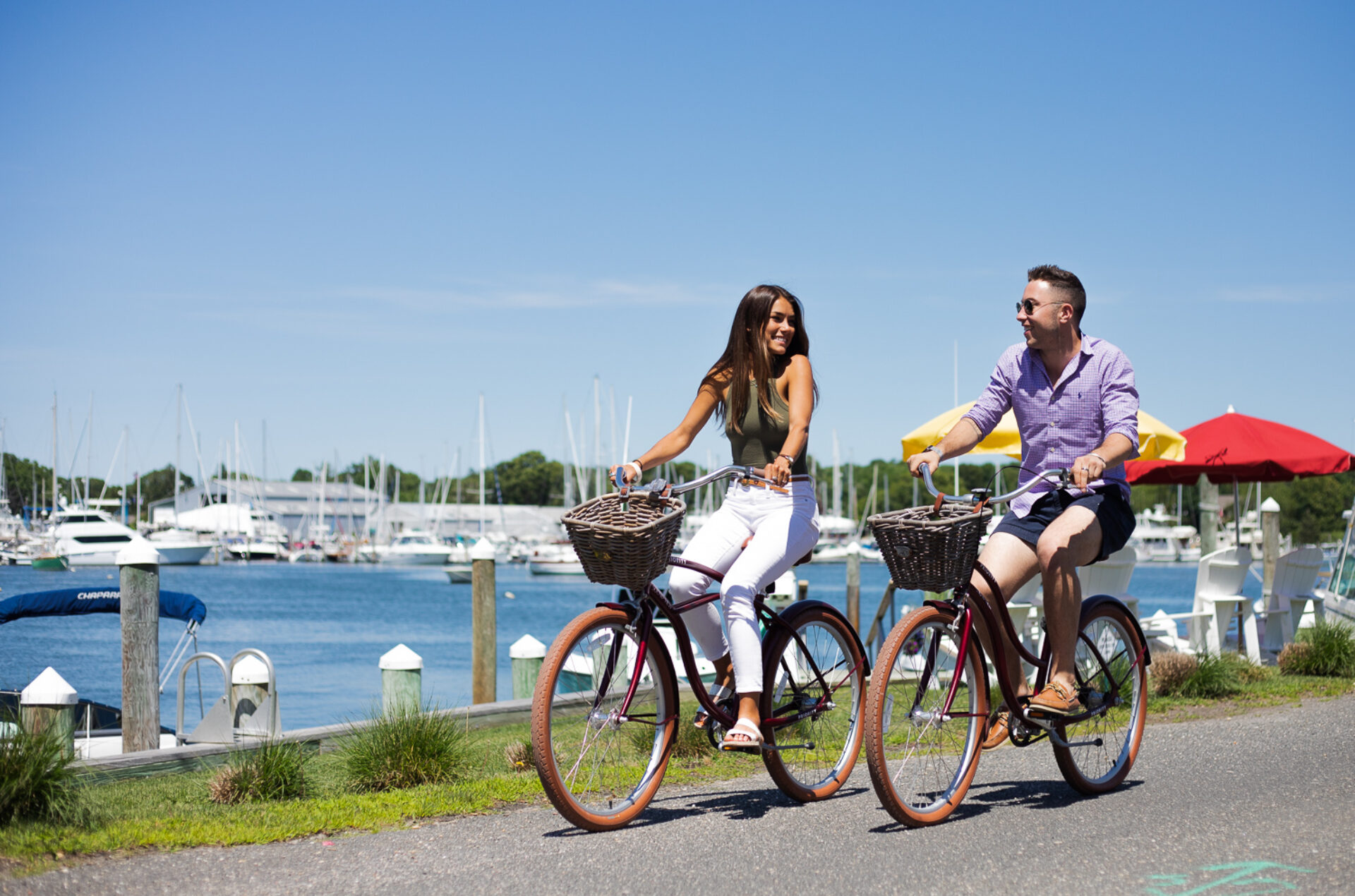 couple on bikes riding along the harbor