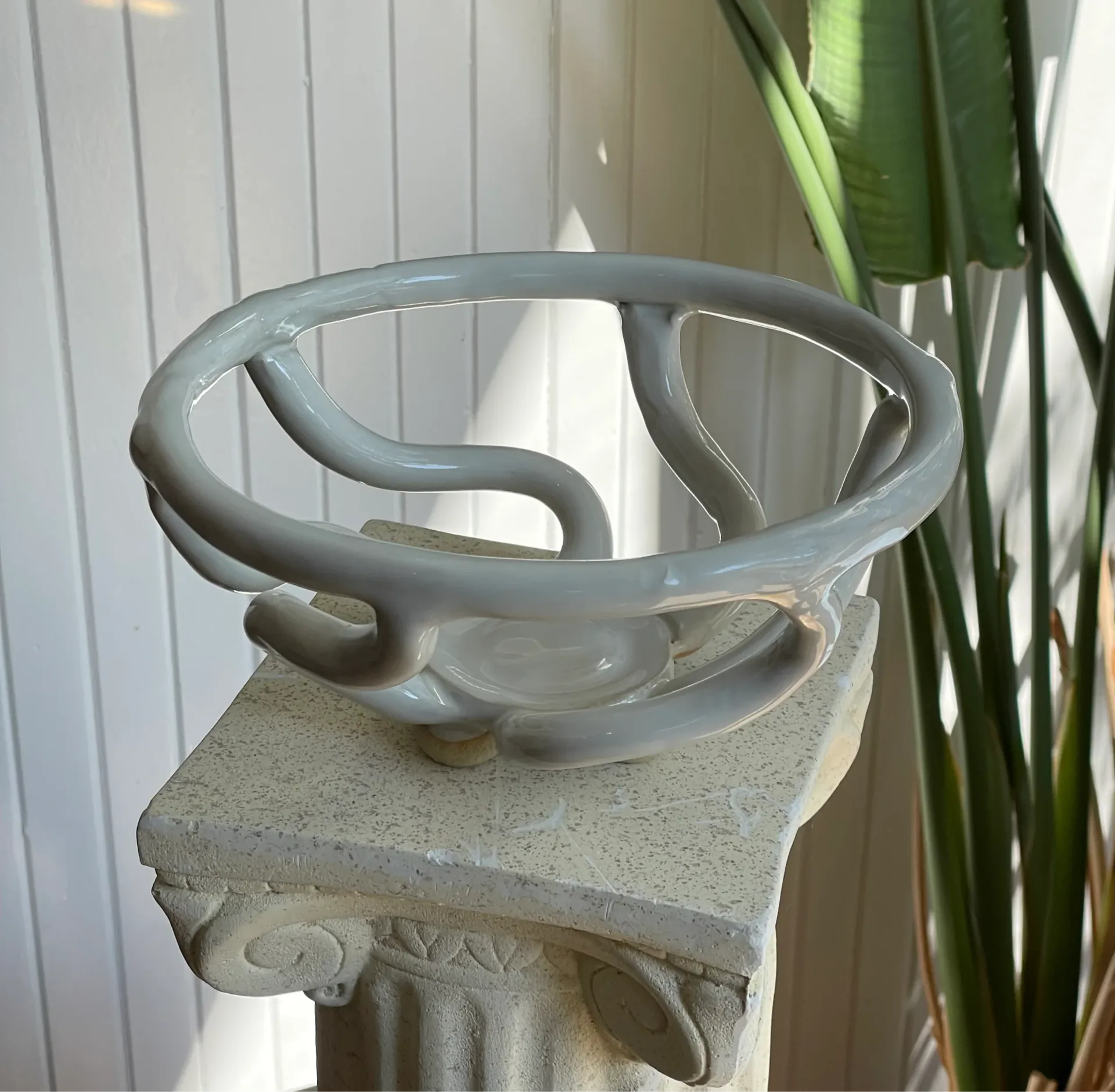 A ceramic basket on a stone pillar.