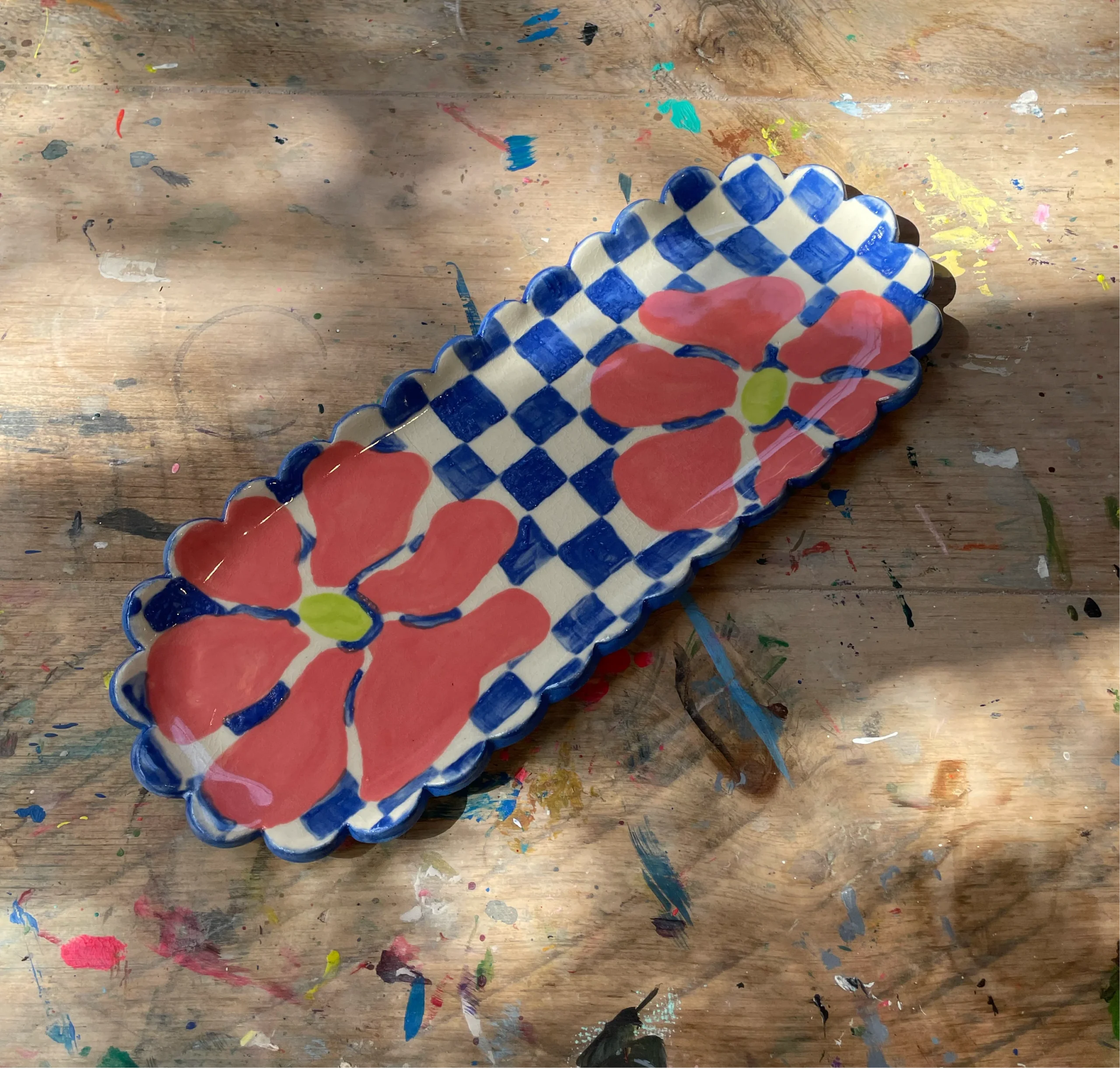 A blue and white checkered platter with pink flowers.