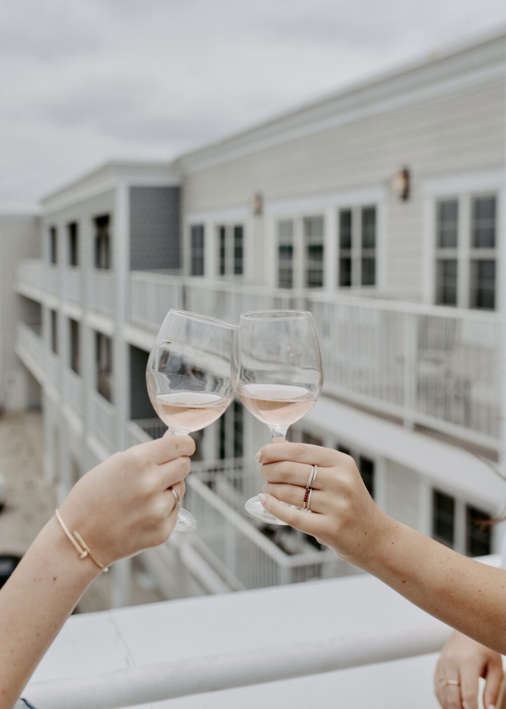 Two glasses of rosé wine being toasted.