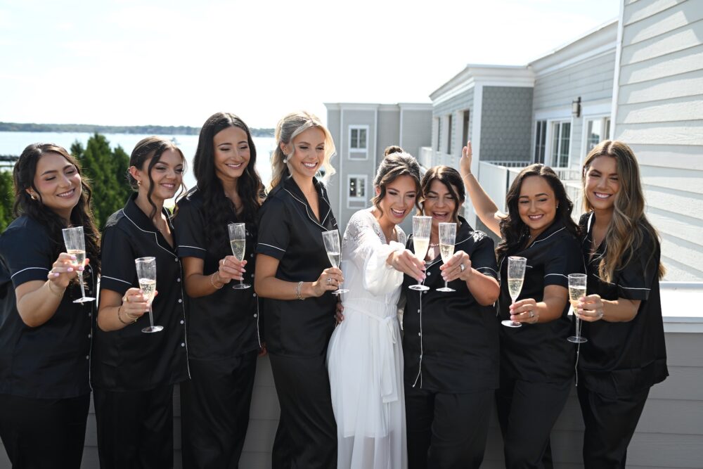 A bride with her wedding party toasting champagne.