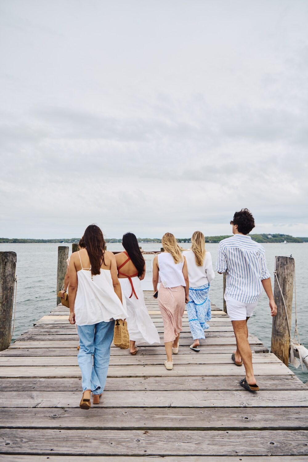 Friends walking down the pier in Greenport, New York.