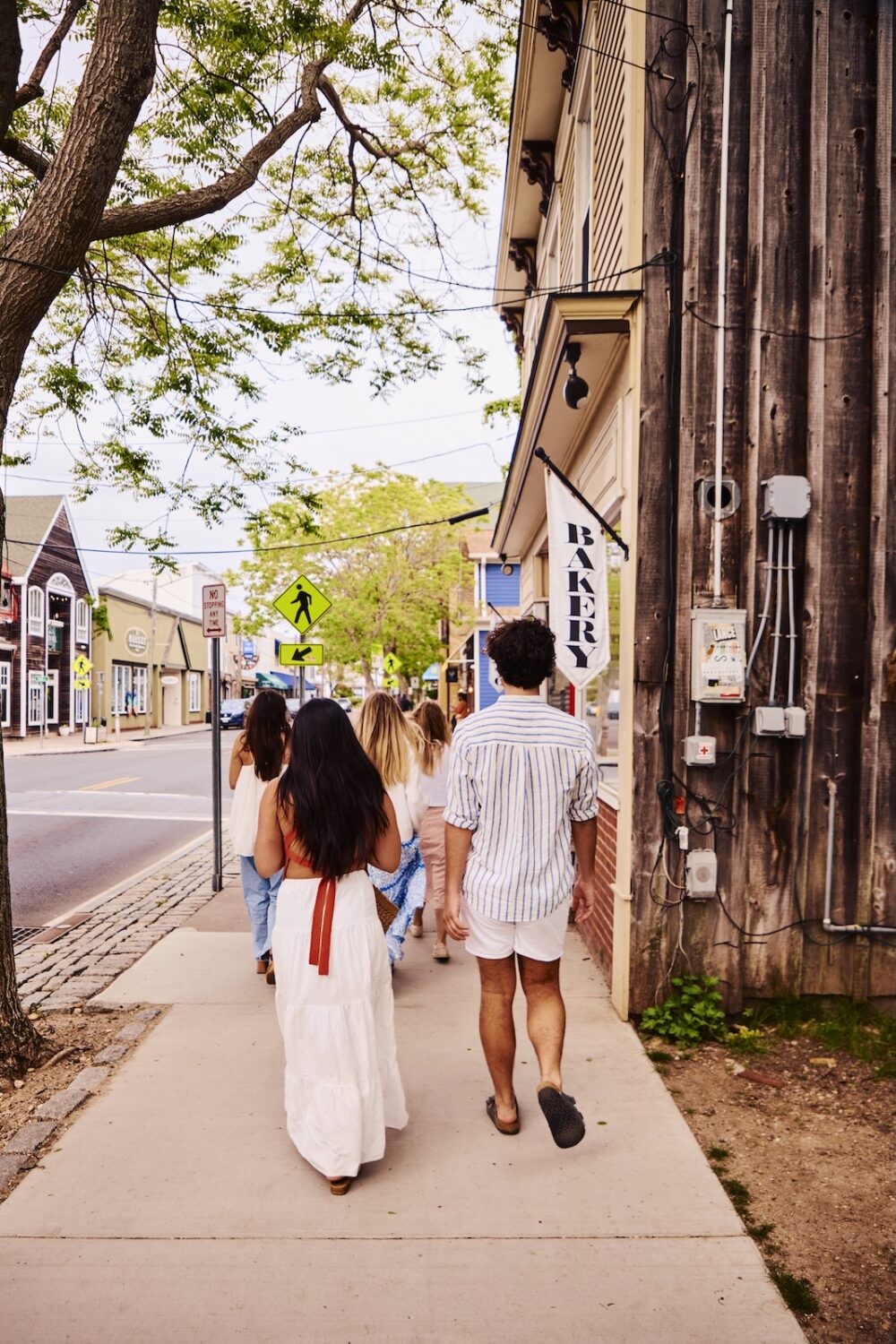 A group of friends walking down the street in Greenport, NY.