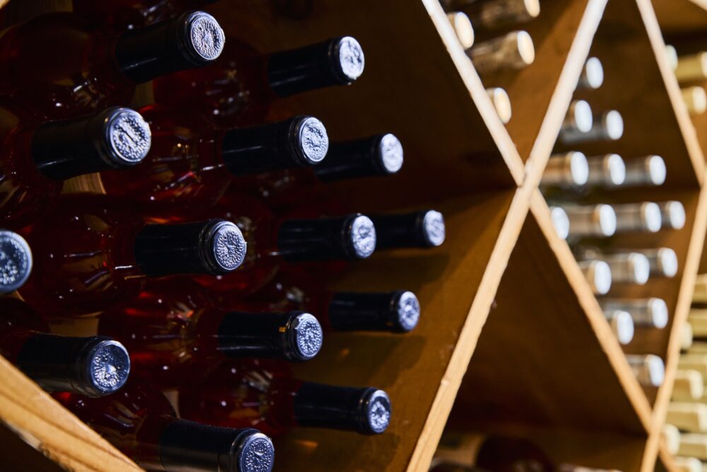 The tops of wine bottles in a cellar.