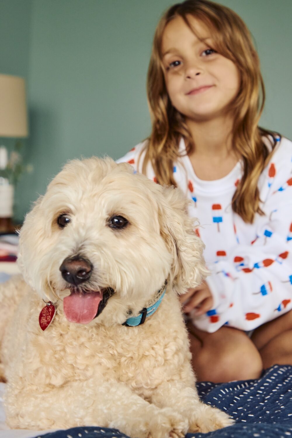 A young girl with her dog, sitting in bed at Harbor Front Inn.