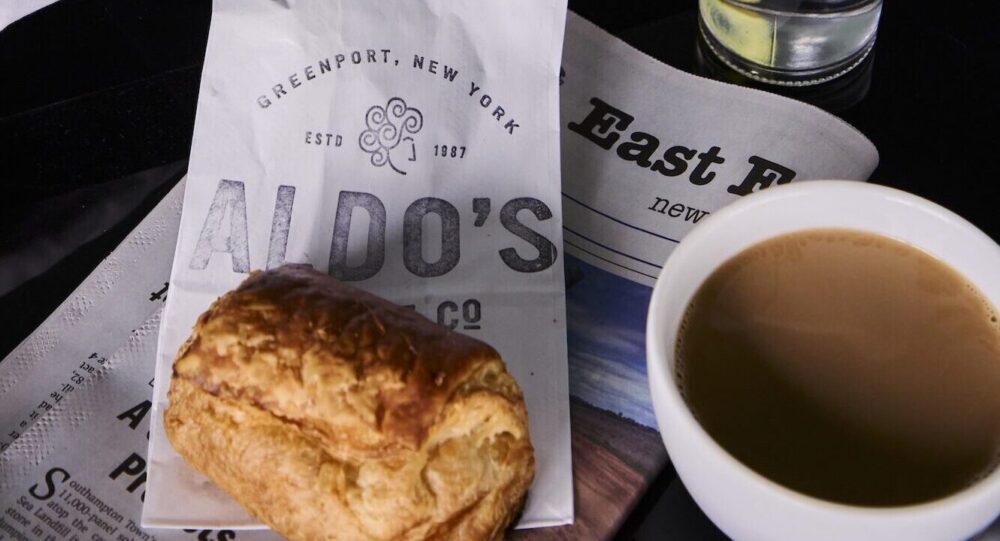 A pastry and cup of coffee next to a guest bedroom.