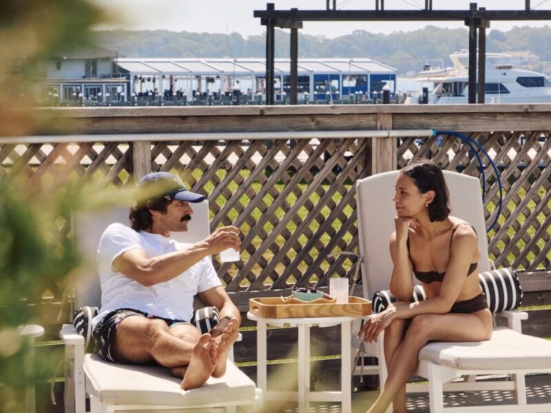 Two people sitting by the pool.