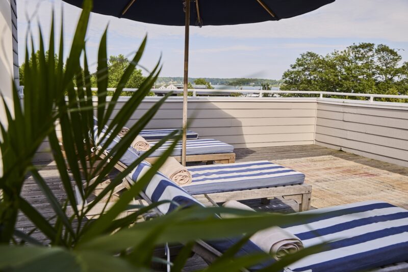 Lounges with blue and white cushions on the Terrace Suite at The Harbor Front Inn.