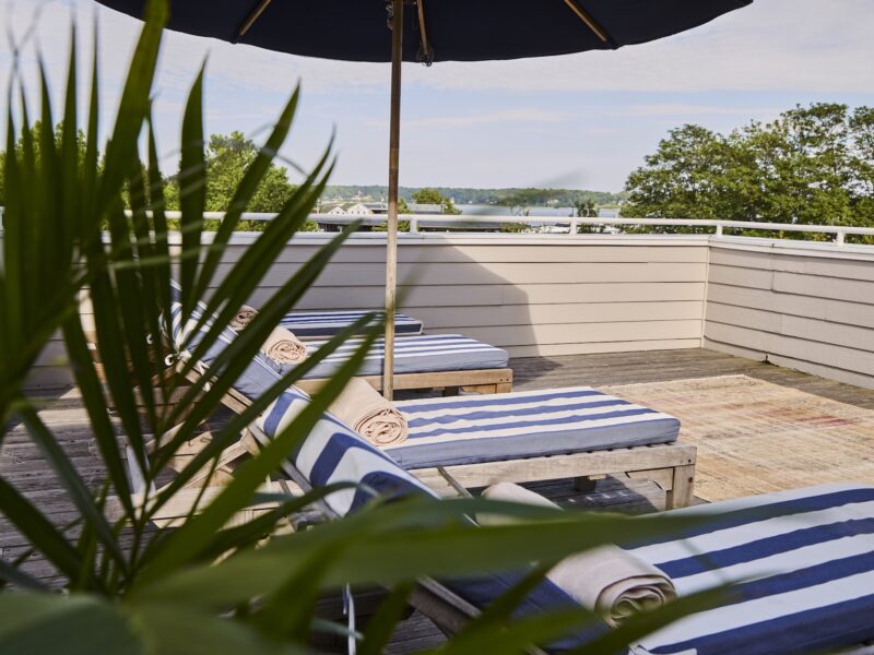 Lounges with blue and white cushions on the Terrace Suite at The Harbor Front Inn.