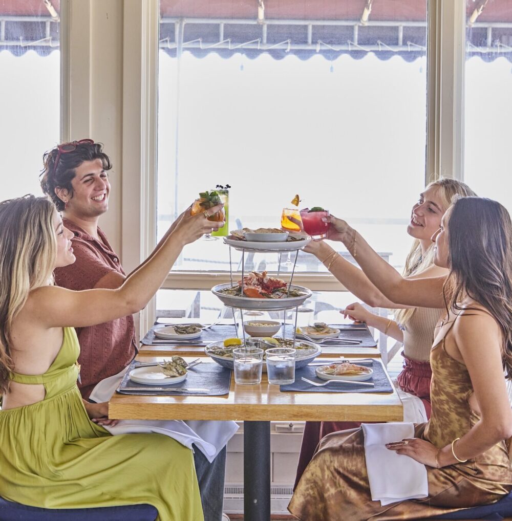 Friends toasting cocktails at The Halyard in Greenport.