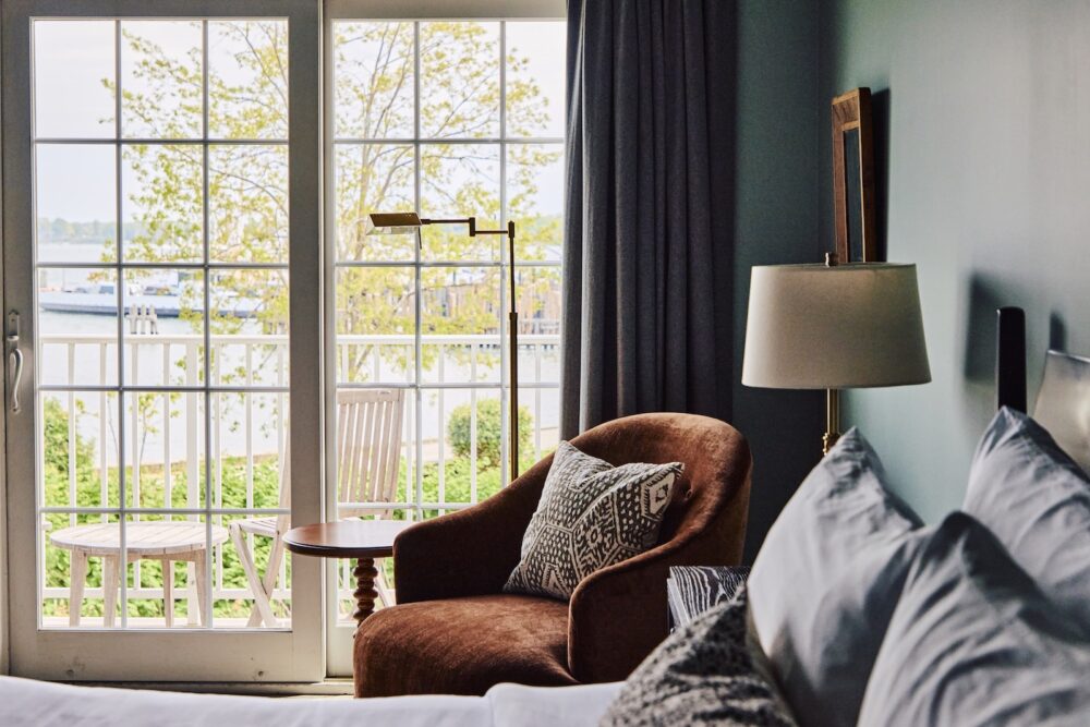 A cozy chair in the corner of a guest bedroom at The Harbor Front Inn.