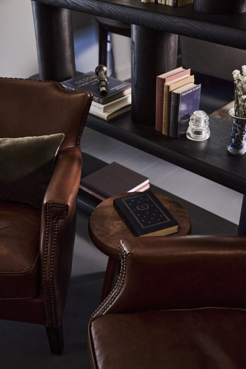 A detailed photo of chairs, side table and books.
